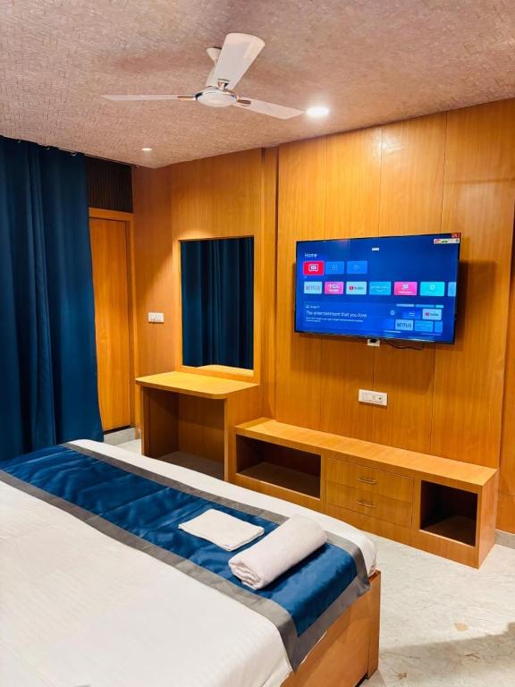 a bedroom with a bed with a tv on the wall at The royal hotel in Bareilly