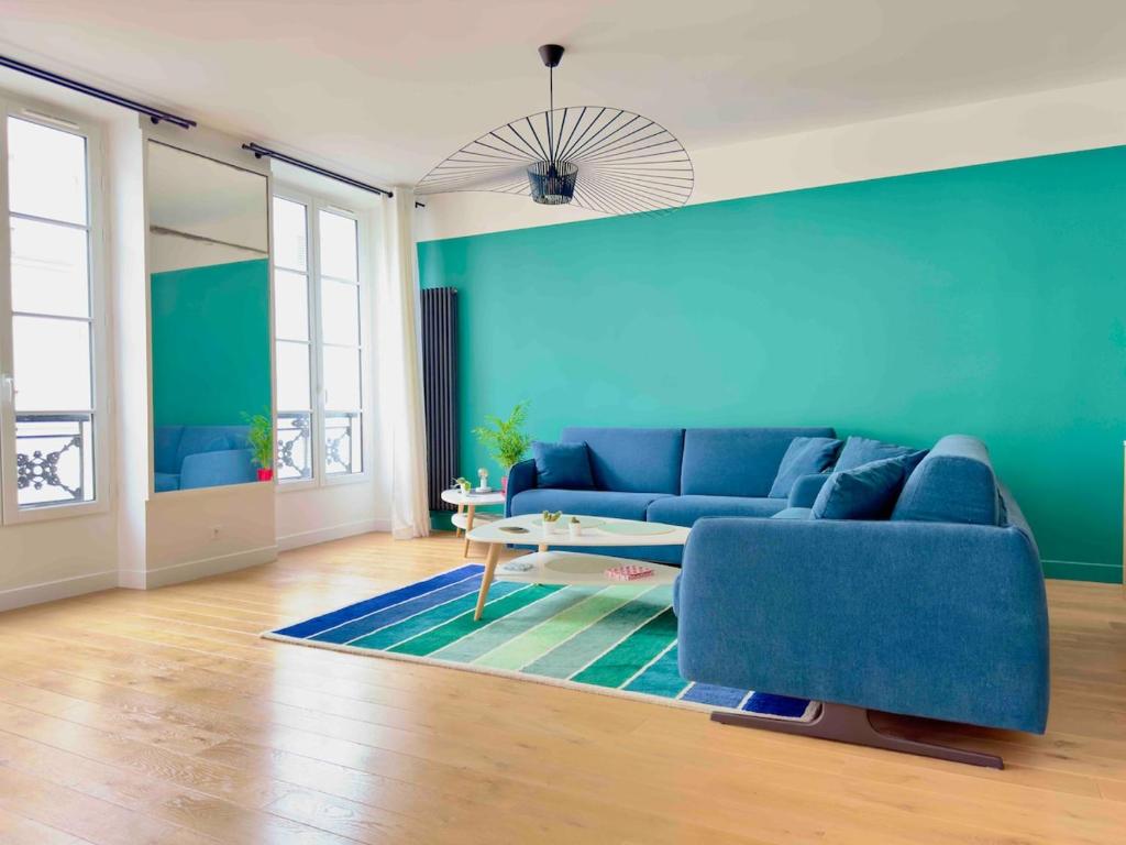 un salon avec un canapé bleu et une table dans l'établissement Spacious 4P Apartment Madeleine Department Stores, à Paris