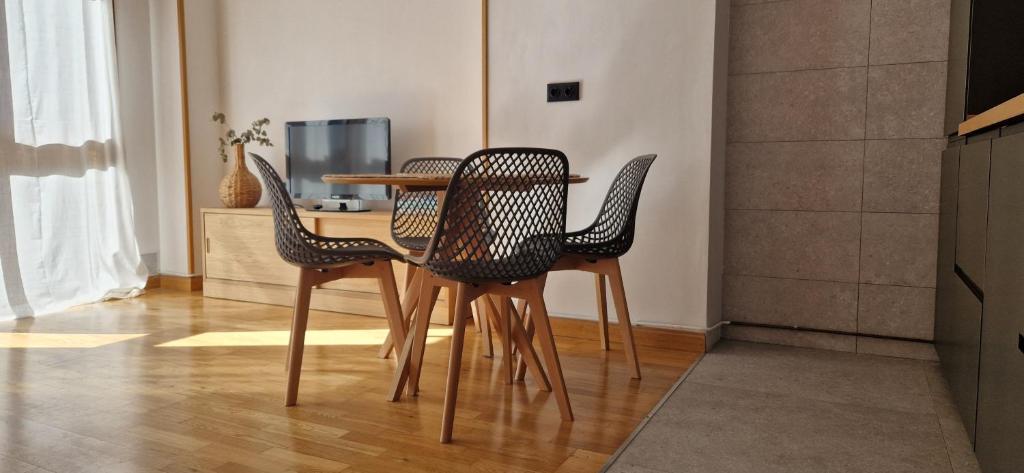 a dining room table with three chairs and a table at Apartamento Vega del Cares by Casas de Los Picos in Arenas de Cabrales