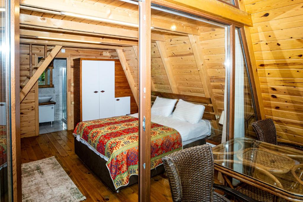 a bedroom with a bed and a glass table at Kackar Resort Hotel in Ayder Yaylasi