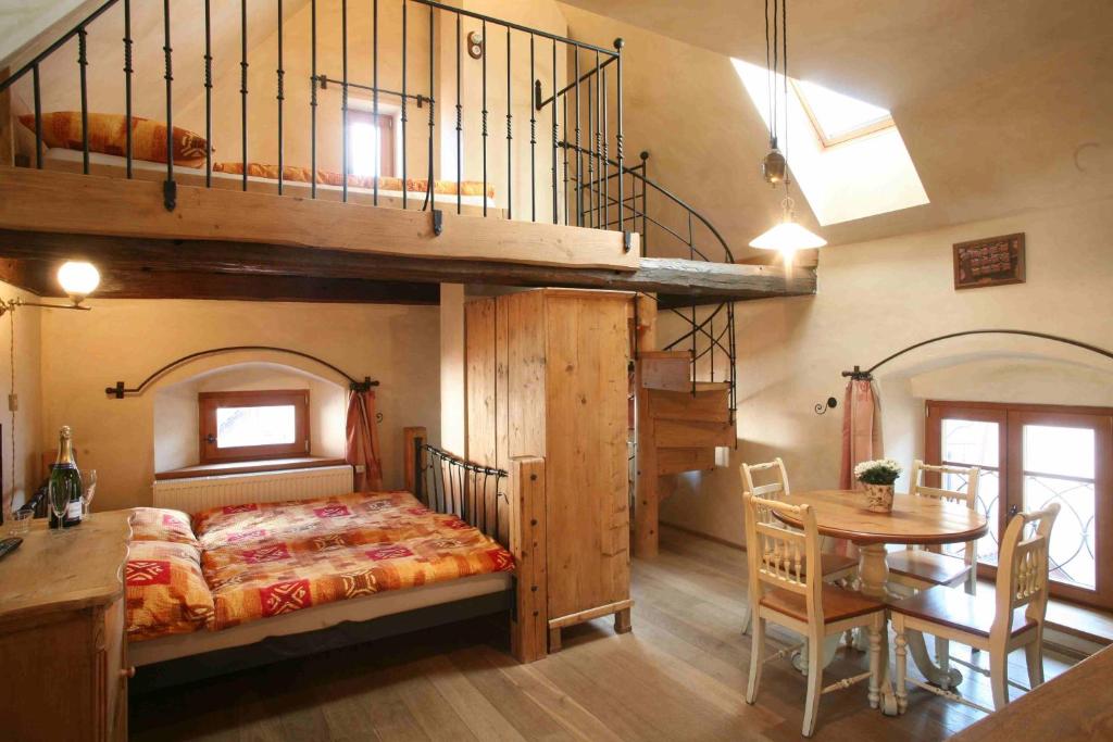 a bedroom with a bunk bed and a dining room at Apartmány Reve in Třeboň