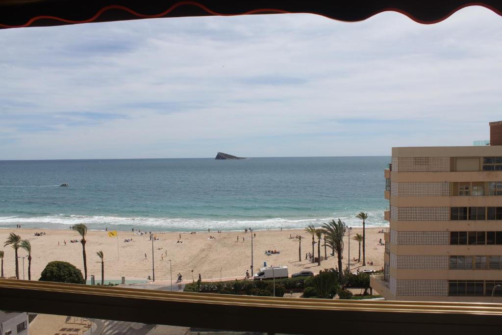 a view of the beach from the balcony of a building at Apartamento ensueño 1a linea playa poniente 6 PAX parking wifi y AC in Benidorm