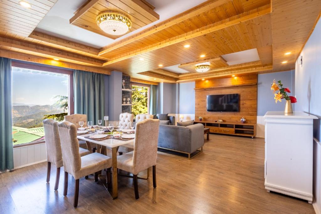 马舍布拉Hostie Heaven View - 3BHK Duplex with Terrace, Mashobra的一间带桌椅和沙发的用餐室