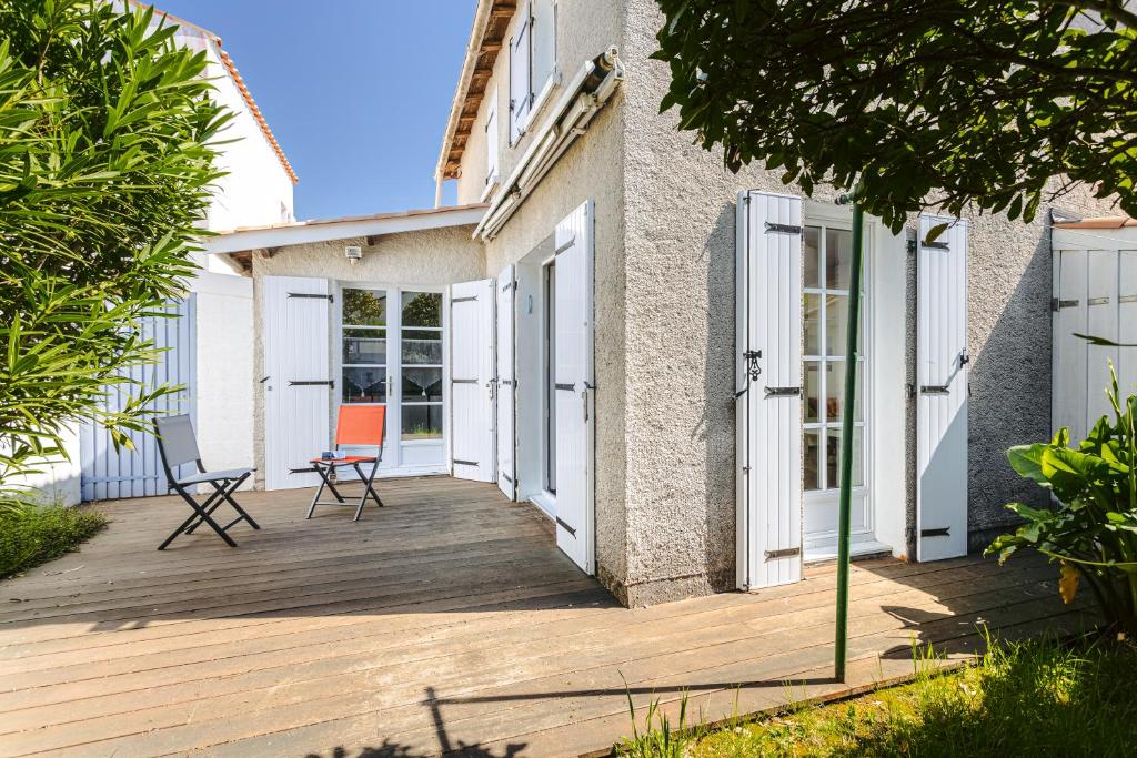 une terrasse en bois avec deux chaises sur une maison dans l'établissement Maison a 4 min du marché et plages, à Saint-Trojan-les-Bains