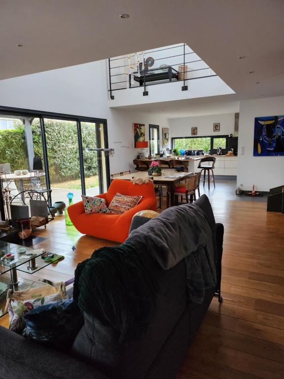 un salon avec un canapé orange et une cuisine dans l'établissement Annie-laure, à La Celle-sous-Gouzon