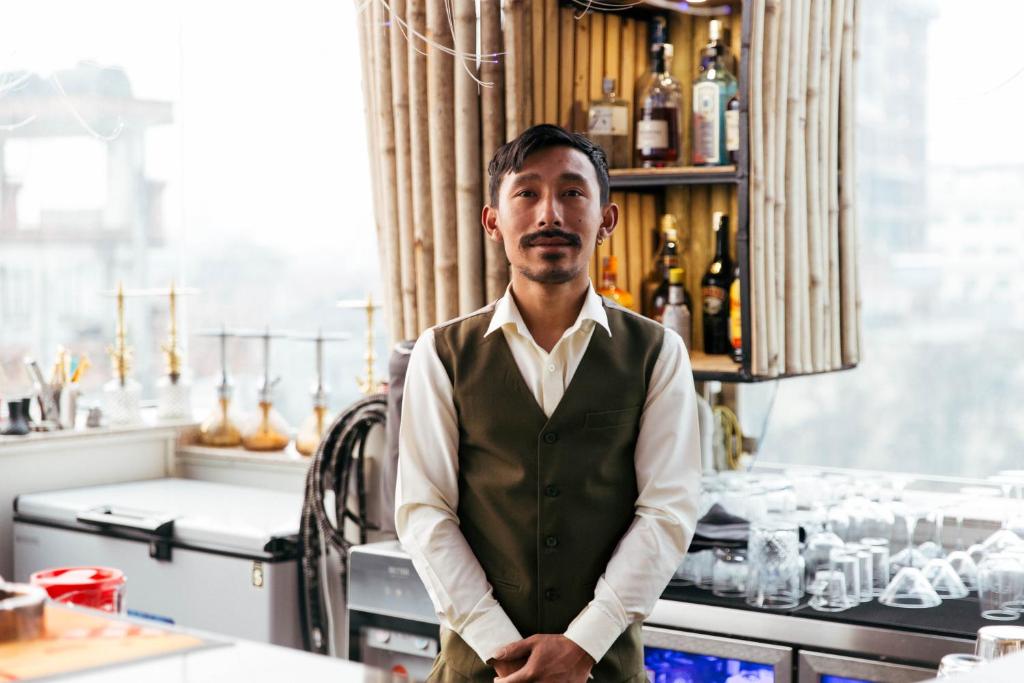 un hombre parado frente a un bar en Hotel snowlion, en Katmandú