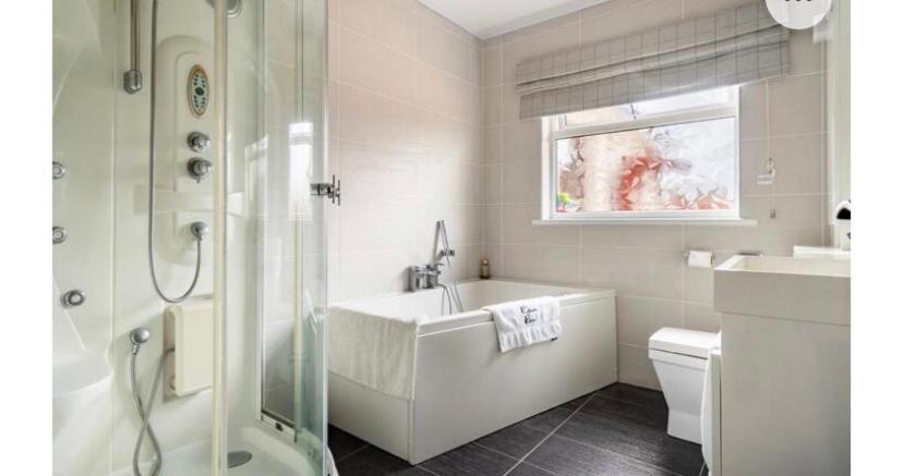 a white bathroom with a tub and a sink at Cullentra House in Cushendall