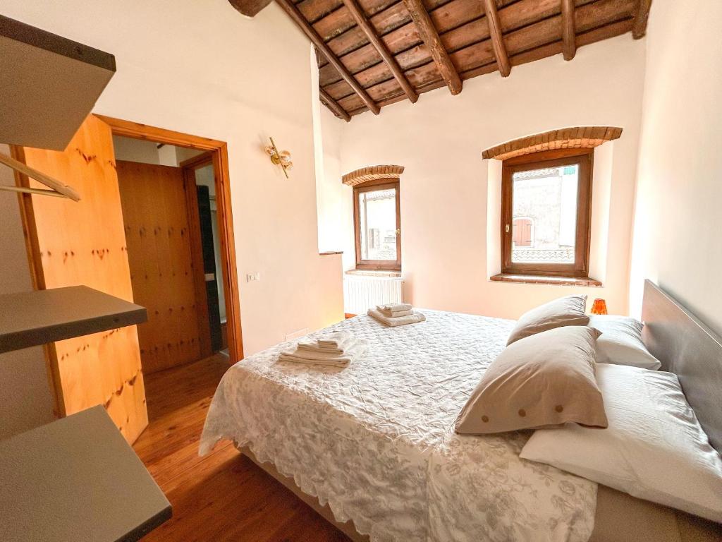 ラツィーゼにあるCasa Margheritaのベッドと2つの窓がある寝室