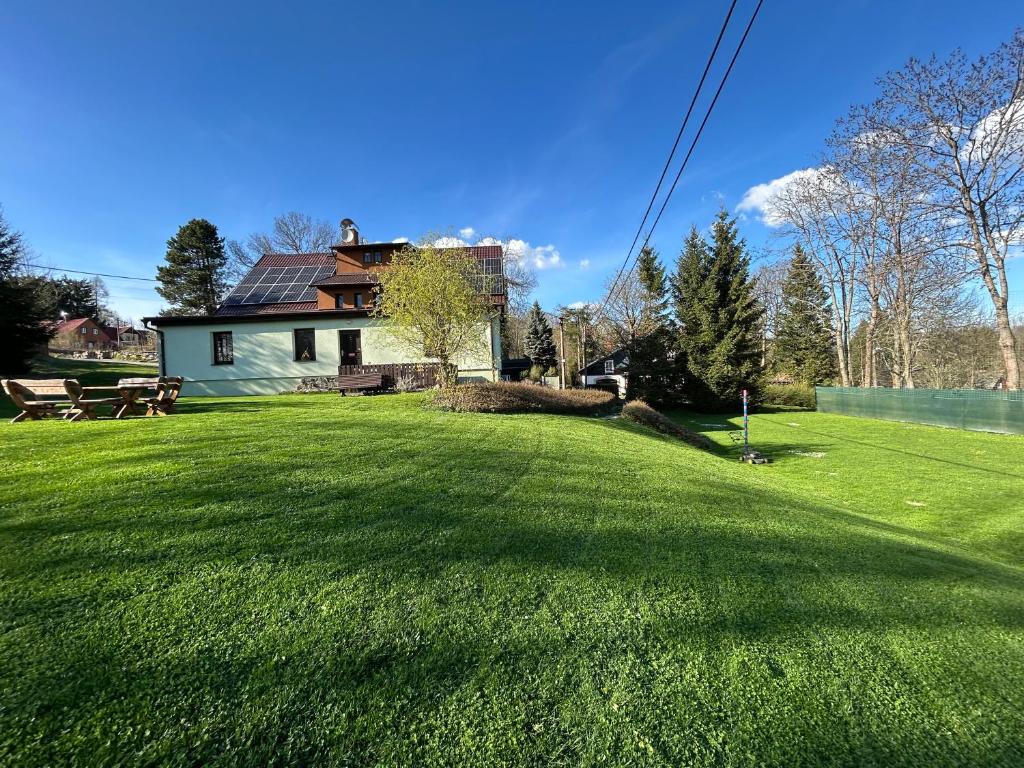 a house with a large yard with a green lawn at Chata U Myšáka in Mařenice