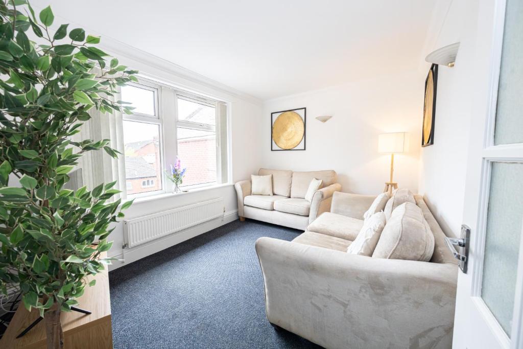 a living room with two white couches and a plant at The Burton- Free Gated Parking in Manchester