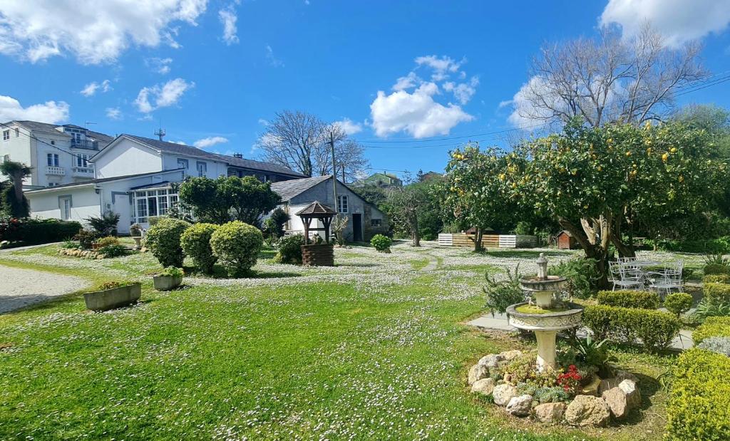 a garden with a bird bath in the middle of a yard at Pensión Casa Elena in Reinante