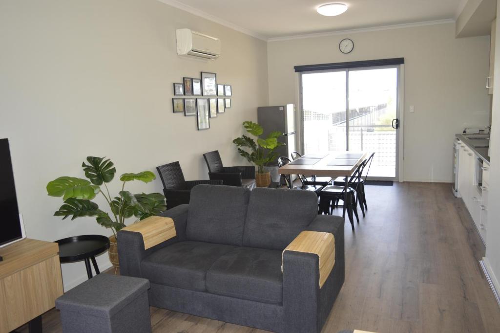 ein Wohnzimmer mit einer Couch und einem Tisch in der Unterkunft Copper Retreat Millennium Apartment in Roxby Downs