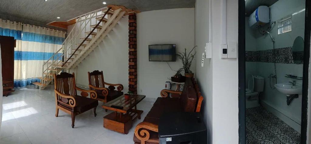 a room with chairs and a sink and a staircase at Dốc home in Da Thien