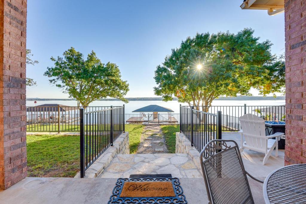 a patio with a fence and a table and chairs at Luxe Lakefront Home with Hot Tub, Dock and Fire Pit in Granbury