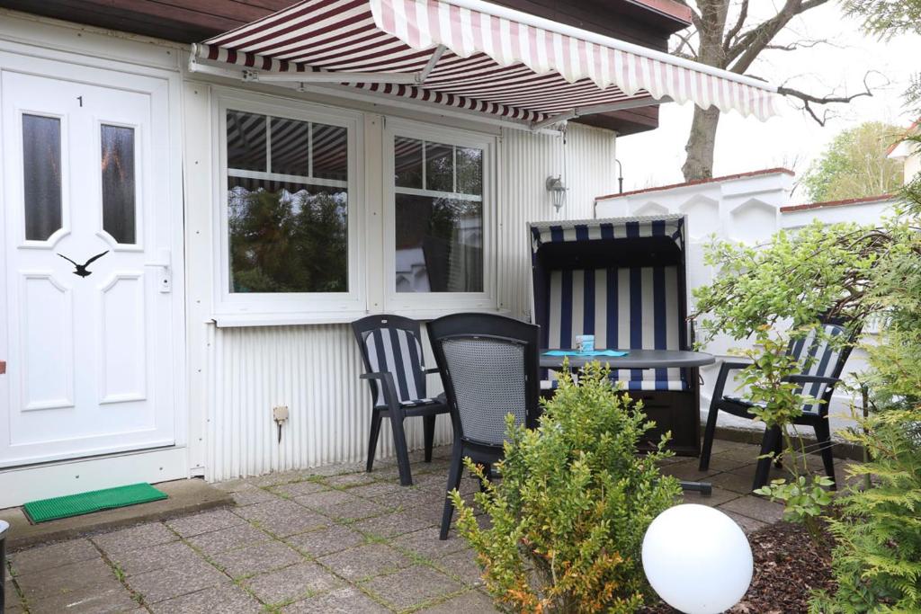 Bungalow Möwe im Ostseeidyll am Waldrand في أوستسيباد نينهاجن: كرسيين وطاولة على الفناء