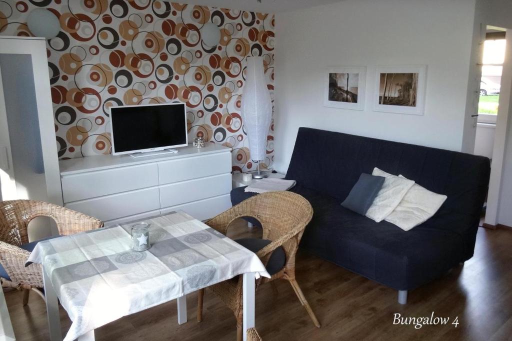 Bungalow Robbe im Ostseeidyll am Waldrand في أوستسيباد نينهاجن: غرفة معيشة بها أريكة وطاولة