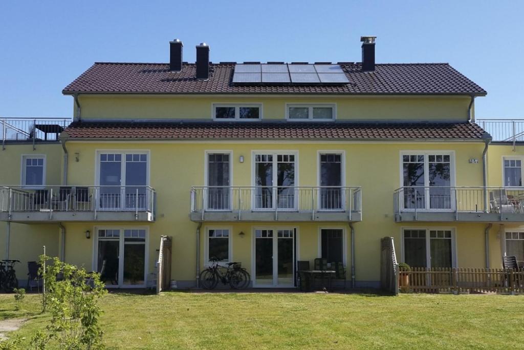 a large yellow house with a large yard at Sommersprosse in Börgerende-Rethwisch