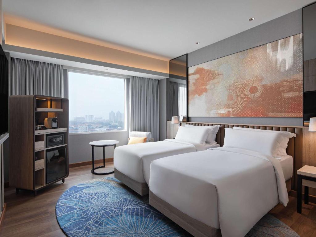 Postel nebo postele na pokoji v ubytování Mövenpick Hotel Jakarta City Centre