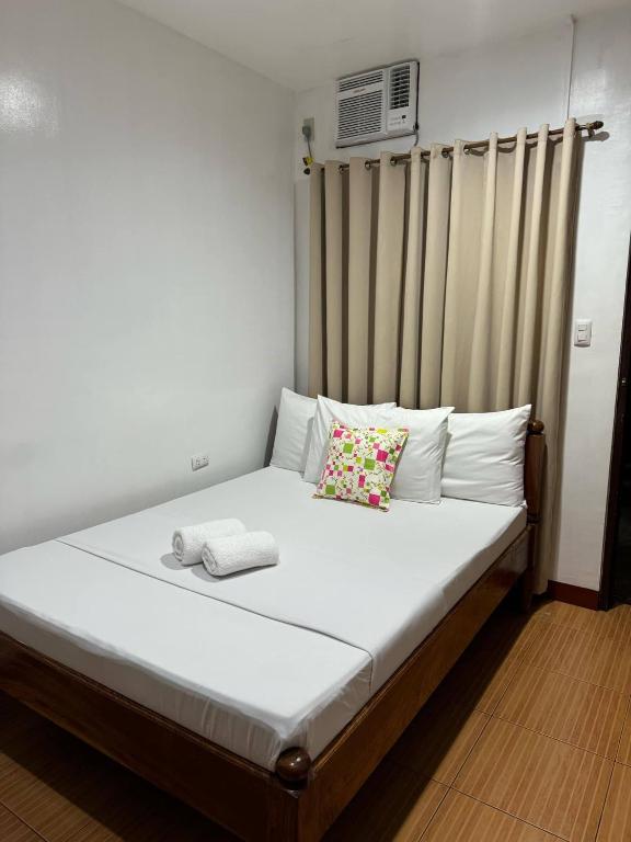 a bedroom with a bed with a radiator and a window at Seascape Lodging House in Coron