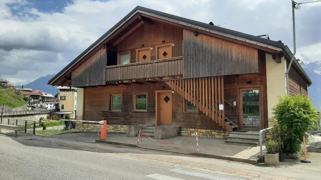 ein kleines Holzhaus an der Straßenseite in der Unterkunft CAMPO BASE CADORE con parcheggio auto e garage moto in Valle di Cadore