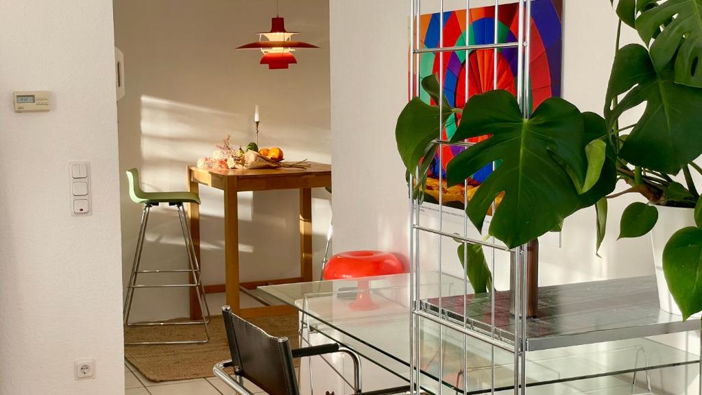 une salle à manger avec une table en verre et une plante dans l'établissement Designerwohnung mit malerischer Terrasse - Modern, Gemütlich & Zentral, à Hochheim am Main