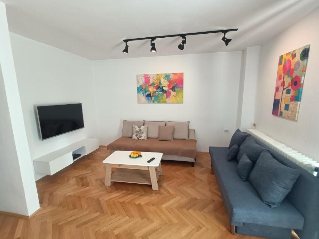 a living room with a couch and a table at Urban View - Main Square Gate Apartment in Skopje