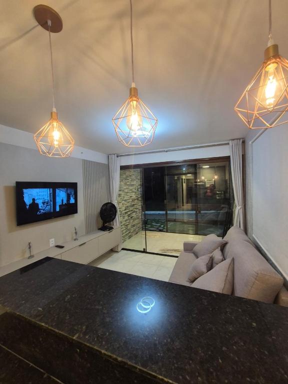 a living room with a couch and a tv and lights at flat 017 Condominio Paraiso da Serra Negra - PE proximo Bodega de Veio in Bezerros