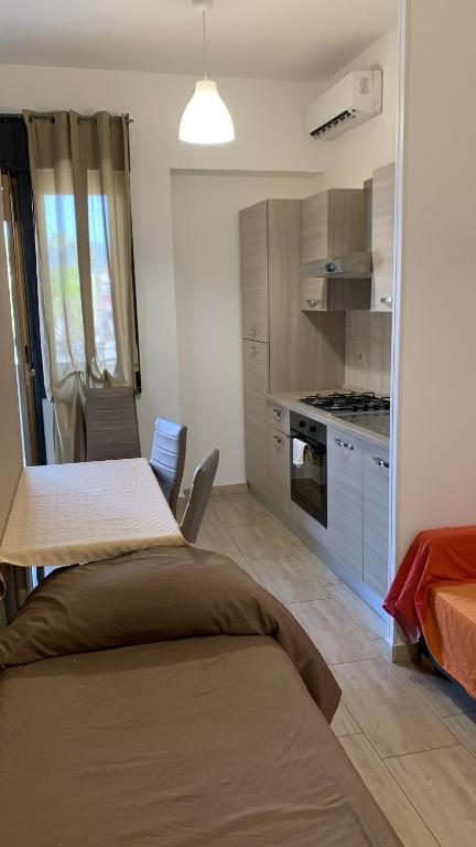 a kitchen with a table and a kitchen with a stove at Home Apollo in Giardini Naxos