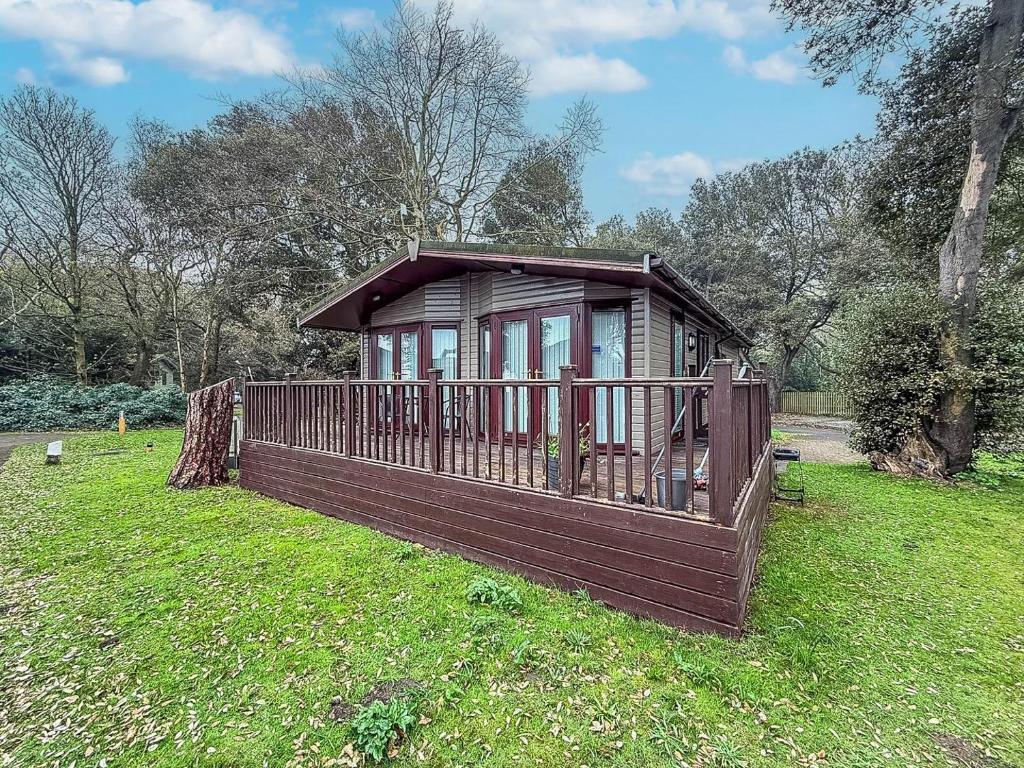 a small cabin in the grass in a field at Pet Friendly, Luxury Lodge With Decking In Suffolk Near The Beach Ref 32108A in Lowestoft