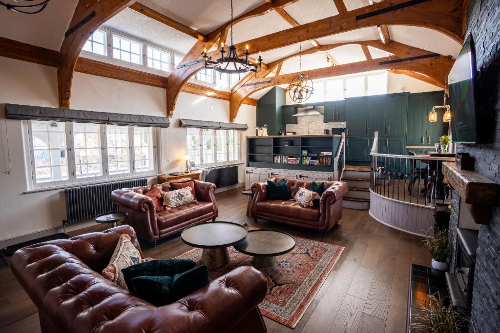 a living room with leather couches and a table at Greta Howe in Keswick