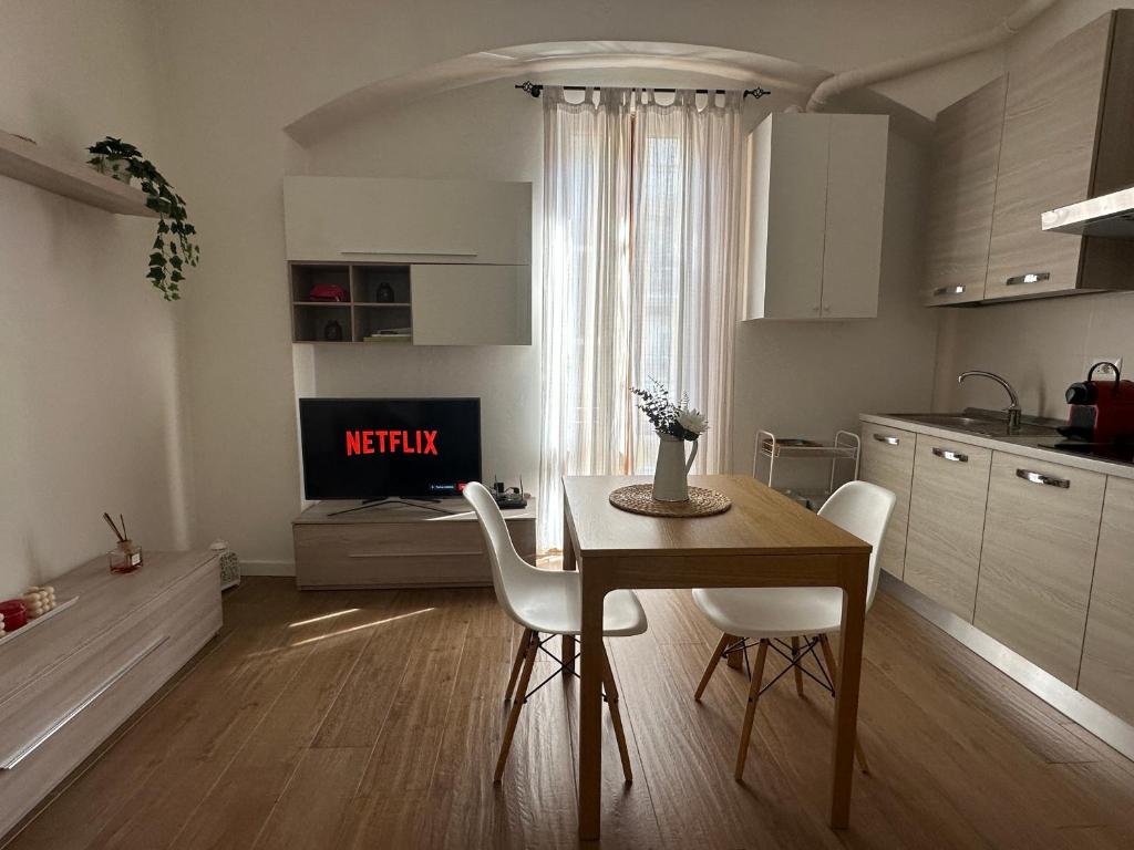 a kitchen with a table and white chairs and a table and a kitchen at Casa Rovani in Sesto San Giovanni