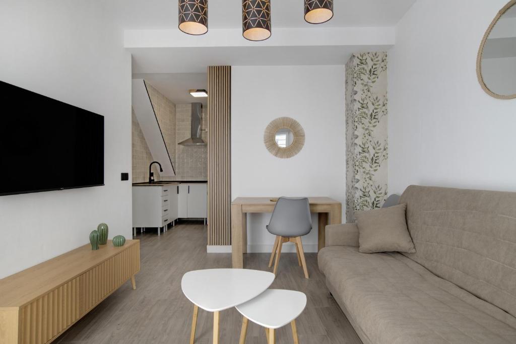 ein Wohnzimmer mit Sofa und Tisch in der Unterkunft Apartamentos Habana 3 in Barbate