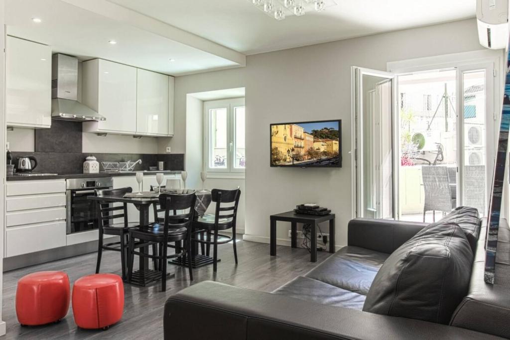 un salon avec un canapé et une table et une cuisine dans l'établissement JOFFRE 9 - Near Masséna Square - Terrace, à Nice