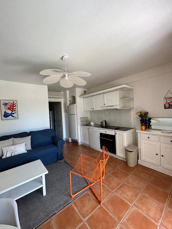 un salon avec un canapé bleu et une cuisine dans l'établissement Appartement 4 à 6 personnes La Ciotat, à La Ciotat