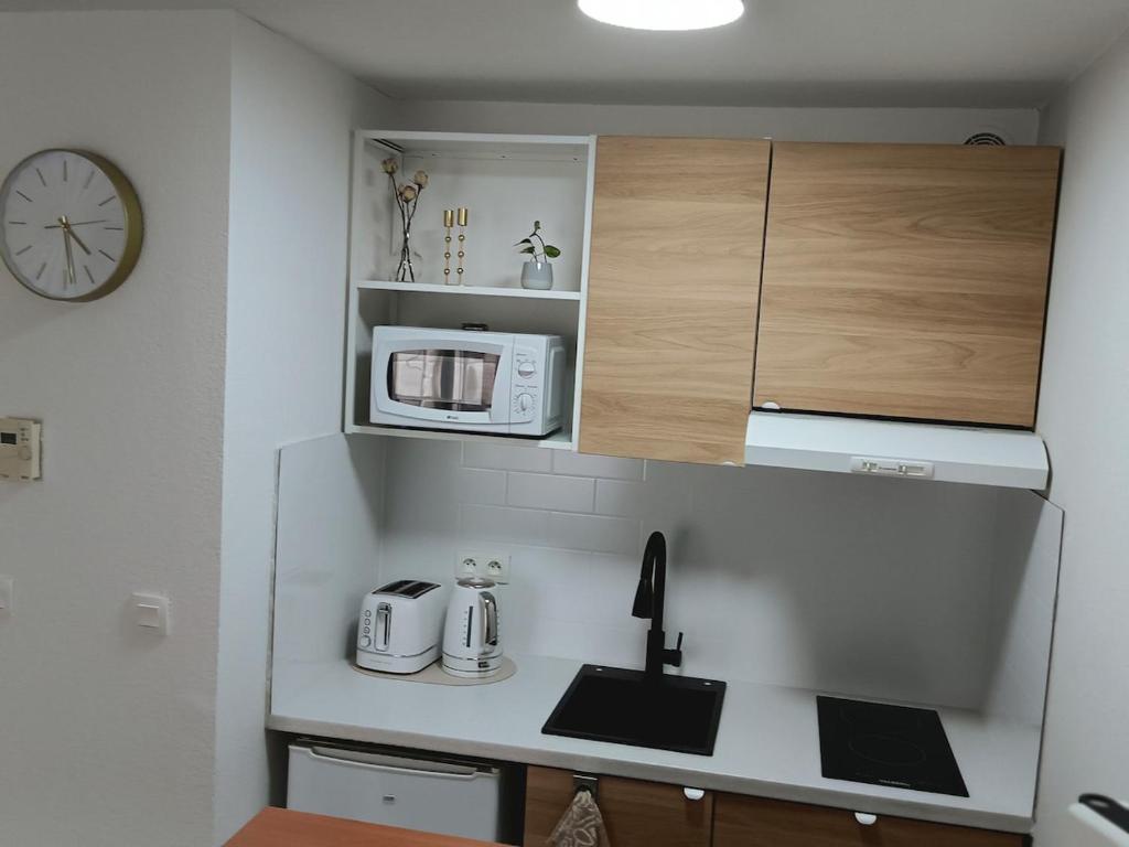 une petite cuisine avec un comptoir et un micro-ondes dans l'établissement Petite Luma, à Arles