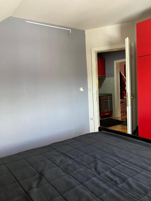 a bedroom with a bed and a red wall at Tanasic in Zlatibor