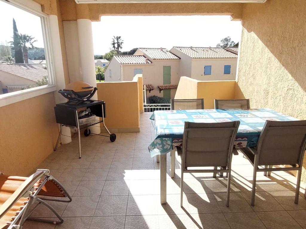 une pièce avec une table et des chaises sur un balcon dans l'établissement Appartement Duplex 3P, 6 Couchages, Proche Plage, Parking, Télévision, Balcon, Ménage Inclus - FR-1-251-722, au Lavandou