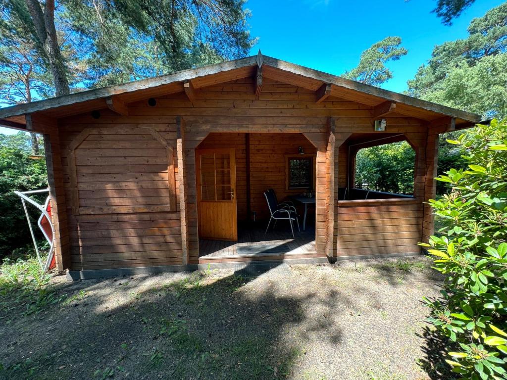 ベルリンにあるFerienhaus Waldblickの小さな木造のキャビン(椅子付)