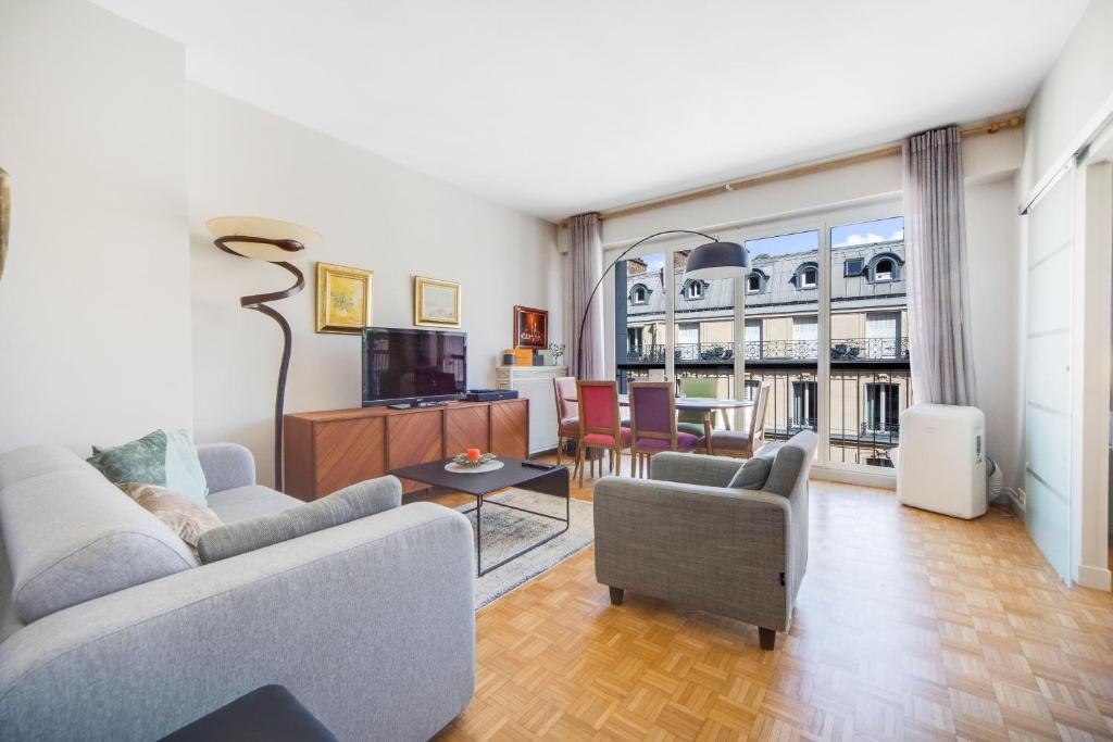 un salon avec un canapé et une table dans l'établissement Triangle d or Champs Elysées, à Paris