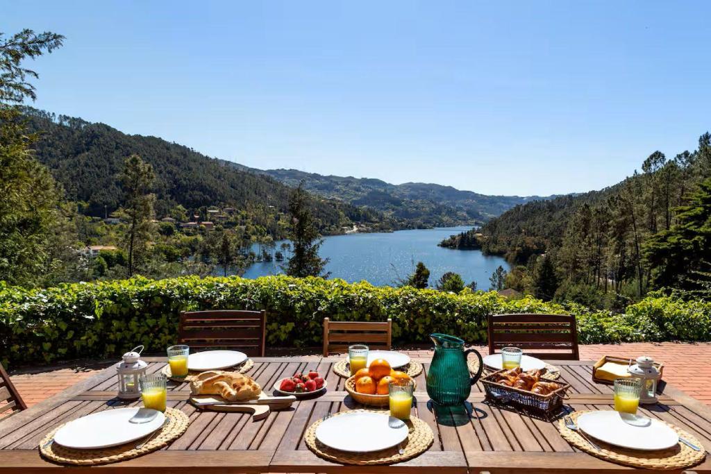 ジェレスにあるGerês Mountain Lake Views by Gerês Casasの木製テーブル(食べ物付)が備わり、湖の景色を望めます。