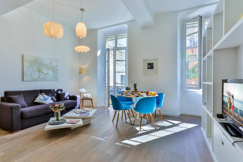 un salon avec un canapé, une table et des chaises dans l'établissement LIBERTÉ - Spacious Apartment City Center w AC, à Nice