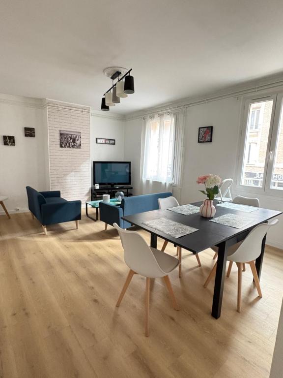 un salon avec une table et un canapé bleu dans l'établissement Grand appartement - Le Brindeau - 3 ch, au Havre
