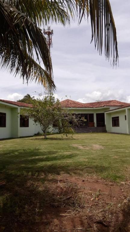 a white building with a tree in the yard at Espaço Casa Cult in Serra