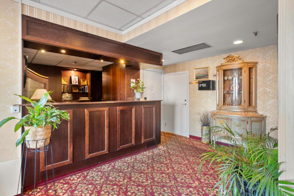 a lobby with a bar and plants in a building at Halden Grand hotell in Halden
