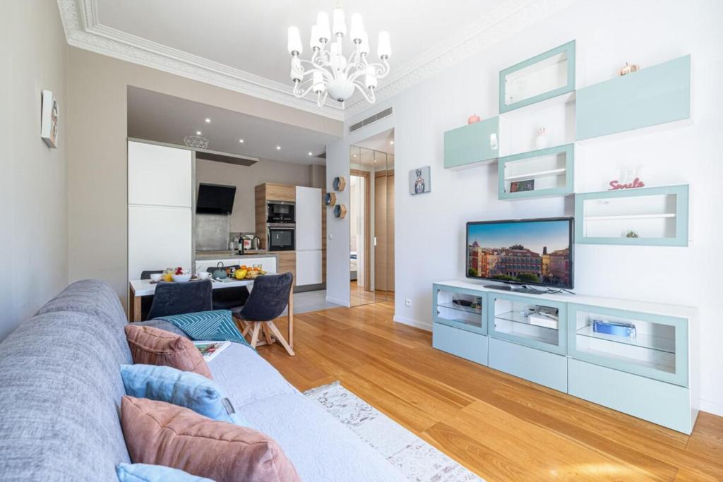 un salon avec un canapé et une télévision dans l'établissement JOFFRE 49-D - Charming 2 bedroom - Carré d'Or, à Nice