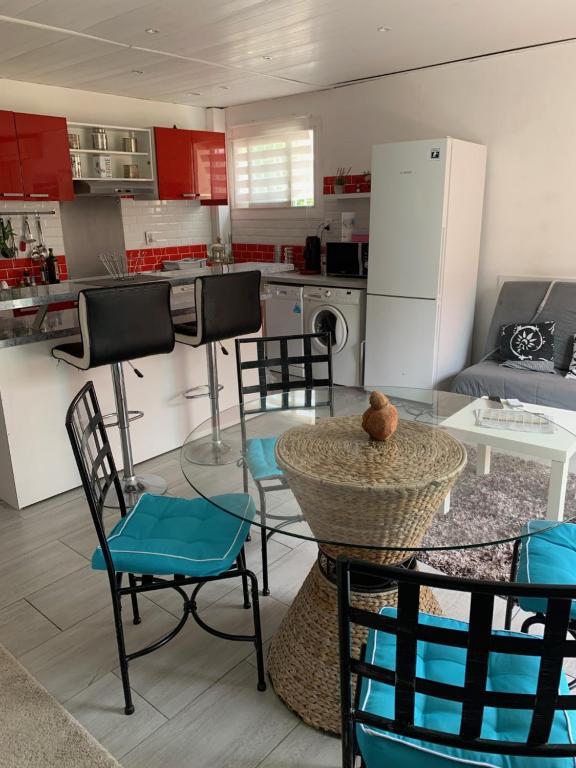 une cuisine avec une table et des chaises et une cuisine avec des placards rouges dans l'établissement Appartement Palavas-les-Flots, Front de mer, à Palavas-les-Flots