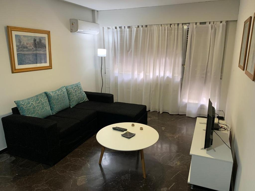 a living room with a black couch and a table at Microcentro Mendoza in Mendoza