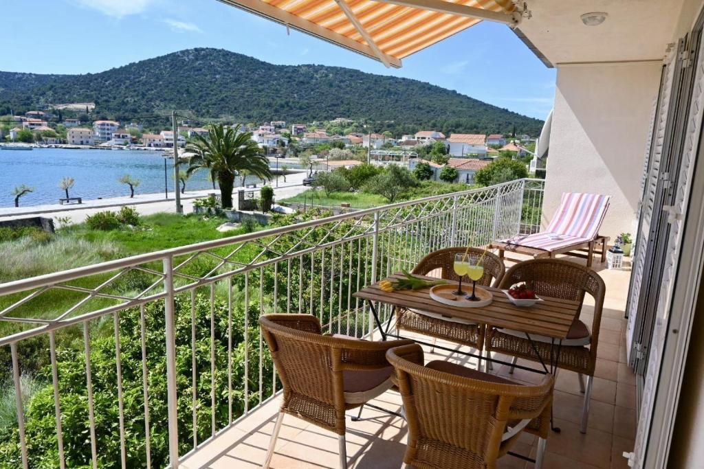 un balcone con tavolo e sedie e vista sull'acqua di Apartment Natasa a Vinišće