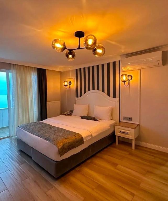 a bedroom with a large bed and a chandelier at Beyaz Ev Otel Restaurant in Eskiömerler