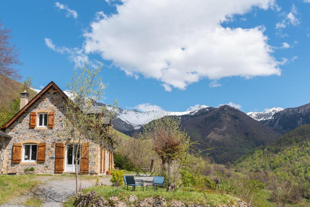 une maison en pierre sur une colline avec des montagnes en arrière-plan dans l'établissement Maison Ty Sioul - Vue montagne, à Aydius